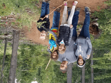 a group of people posing for a picture in the woods with one wearing a sweatshirt that says the north face