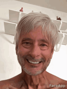 a man with gray hair and a beard is smiling and has faceapp written on the bottom