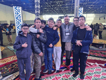 a group of young men are posing for a picture in front of a sign that says ' a ' on it