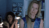 a woman wearing headphones looks at the camera while another woman talks on a phone
