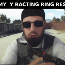 a man with a beard wearing sunglasses and a hat is holding a gun under the words my racing ring res