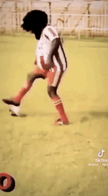 a man is kicking a soccer ball on a soccer field .