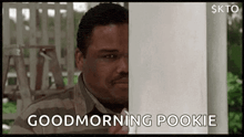 a man in a striped shirt is peeking out from behind a pole and says `` good morning pookie '' .