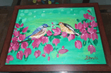 a framed painting of two birds sitting on a tree branch