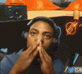 a man wearing headphones covering his mouth with his hands and a twitter logo in the background