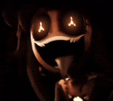 a close up of a cartoon character 's face with glowing eyes in the dark .