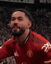 a man wearing a red adidas shirt is laughing and sticking his tongue out