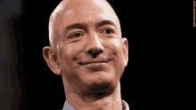 a close up of a man 's face with a black background and a caption that says amazon