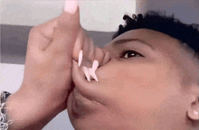 a close up of a person making a funny face with their fingers in their nose .