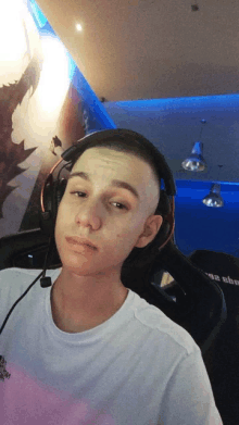 a young man wearing headphones is sitting in a chair with a microphone