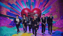 a group of men are standing next to each other in front of a heart .