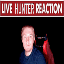 a man sitting in front of a live hunter reaction sign