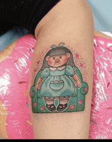 a tattoo of a girl in a blue dress sitting in a green chair