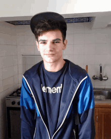 a young man wearing a black hat and a shirt that says " ement "