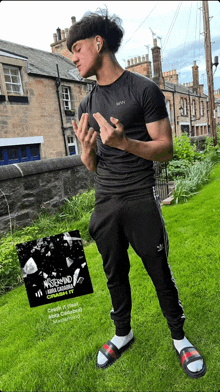 a man in a black shirt and black pants is standing in front of a building