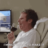 a man is sitting in a chair drinking a glass of wine and making a face .