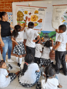 a group of children are sitting in front of a ciencias naturales poster