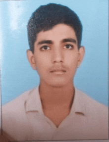 a young man in a white shirt stands in front of a blue wall