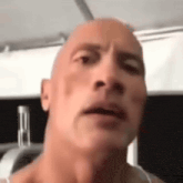 a close up of a man 's face with a bald head and a serious look on his face .