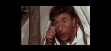 a man with a surprised look on his face is looking out of a window .