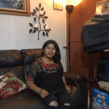 a woman sits on a couch next to a box of scrabble plus