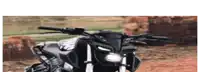 a black and white motorcycle is parked in front of a brick wall .