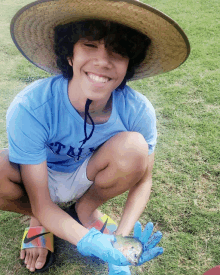 a young boy wearing a hat and a blue shirt that says ' texas ' on it