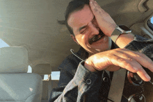 a man with a watch on his wrist is sitting in a car