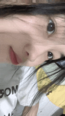 a close up of a girl 's face with a white shirt that says dom on it