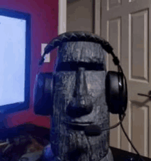 a statue of a moai head wearing headphones and a microphone .