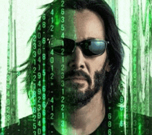 a man with a beard and sunglasses is standing in front of a green screen with numbers on it .