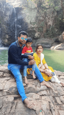 a family posing for a picture in front of a waterfall taken by a real quad camera