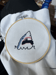 a cross stitch of a shark 's mouth is being worked on