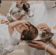 a baby is being baptized by a priest in a church