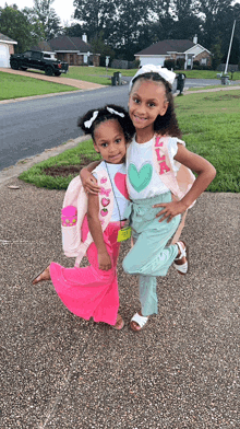 two little girls standing next to each other with one wearing a shirt that says ella