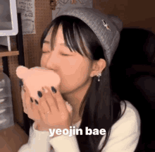 a girl is kissing a stuffed animal with the word yeojin bae on the bottom right