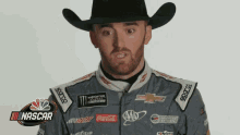 a man in a cowboy hat is wearing a nascar uniform