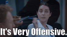 a woman in a lab coat is being threatened by a man with the words " it 's very offensive " below her