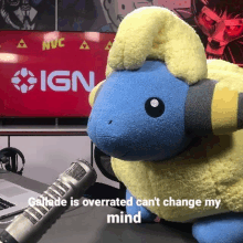 a stuffed animal is sitting on a table in front of a microphone and a sign that says ign