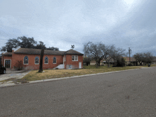 a church with stained glass windows sits on the side of a road