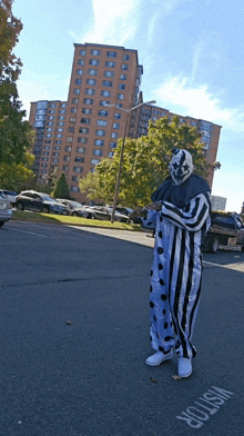 a man in a clown costume is standing in front of a visitor sign on the side of the road