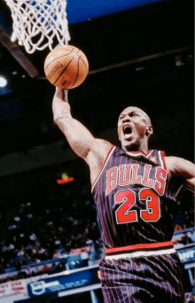 a basketball player wearing a bulls jersey is about to dunk