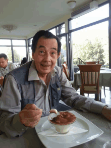 a man sitting at a table with a plate of food