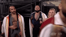 a group of wrestlers are standing next to each other with a woman holding a microphone that says aew