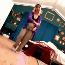 a woman wearing headphones is standing in a bedroom with a bed