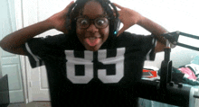 a girl wearing headphones and a black shirt with the number 89 on it