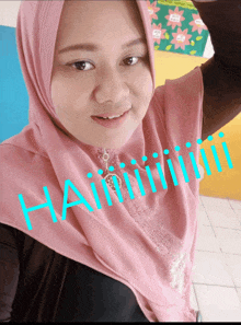 a woman wearing a pink hijab has the word hainii written on her face