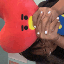 a person covering their face with a stuffed animal with the number 10 on its face