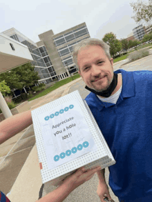 a man holding a box that says appreciate you a hole iot