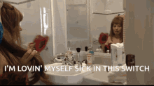 a woman brushing her hair in front of a mirror with the words i 'm lovin ' myself sick in this